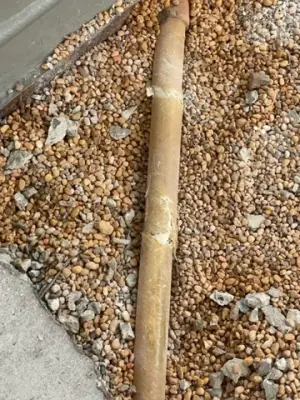Close view of an exposed pipe within aggregate bedding.