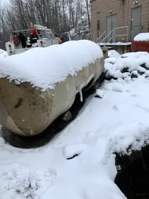 Existing cylindrical tank beside the snow-covered work area.