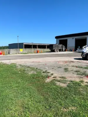 Facility building and open ground before fueling-area construction.