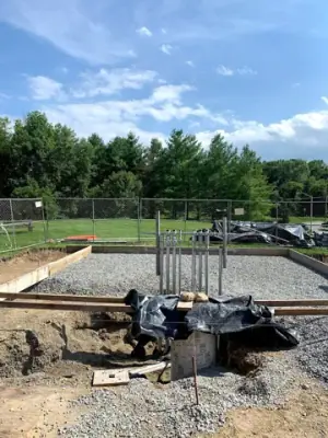 Equipment base and pipe risers at the edge of the work area.