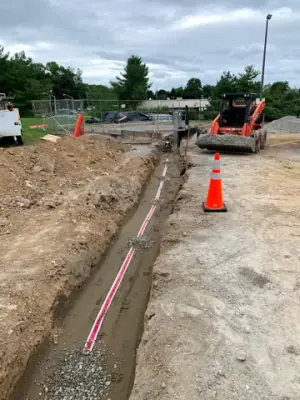 Open utility trench and conduit runs connecting the facility to the fueling area.