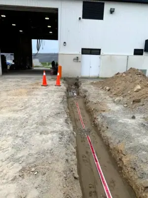 Open utility trench and conduit runs connecting the facility to the fueling area.