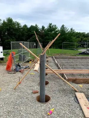 Timber forms, pipe risers, and aggregate base before concrete placement.