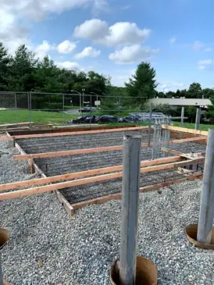 Vertical pipe risers above the reinforced foundation base.