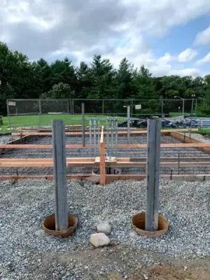 Vertical pipe risers above the reinforced foundation base.