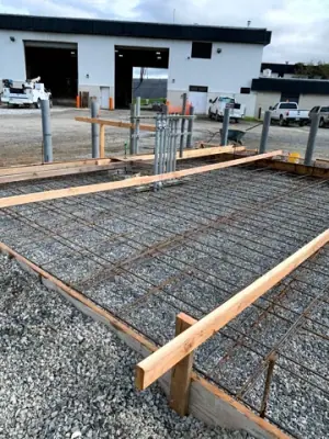 Reinforcing steel and timber forms across the prepared foundation.
