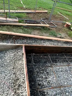 Reinforcing steel and timber forms across the prepared foundation.