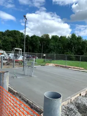 Newly placed concrete pad surrounding the pipe risers.