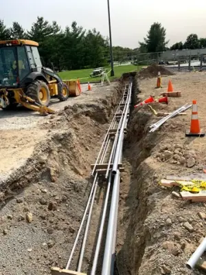 Parallel conduits routed along the open utility trench.