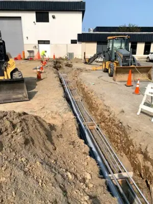 Parallel conduits routed along the open utility trench.