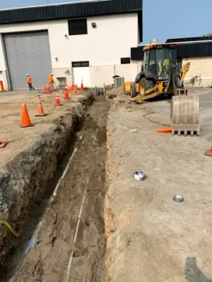 Underground utility runs and risers exposed before backfilling.