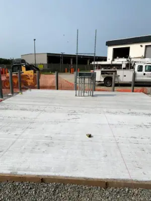 Finished concrete foundation with projecting pipe risers.