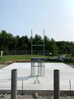 Finished concrete foundation with projecting pipe risers.