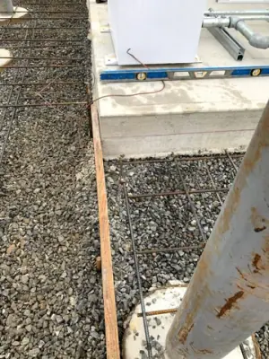 Protective posts and reinforced concrete forms alongside the installed tanks.