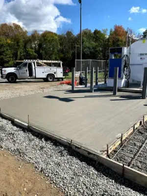 Concrete apron around the installed tanks and dispensing equipment.