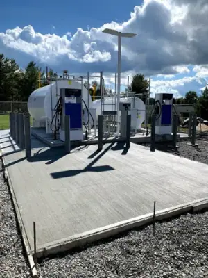 Concrete apron around the installed tanks and dispensing equipment.