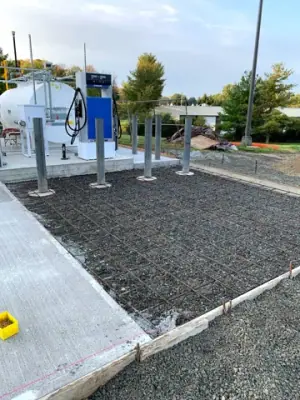 Freshly finished concrete surrounding the tank installation.