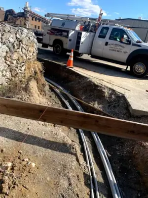 Parallel conduits and vertical risers within the prepared foundation area.