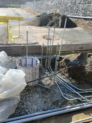 Parallel conduits and vertical risers within the prepared foundation area.
