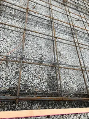 Reinforced concrete formwork over a compacted aggregate base.