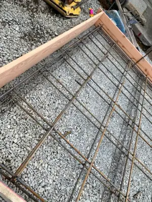 Reinforced concrete formwork over a compacted aggregate base.