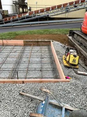 Reinforced concrete formwork over a compacted aggregate base.