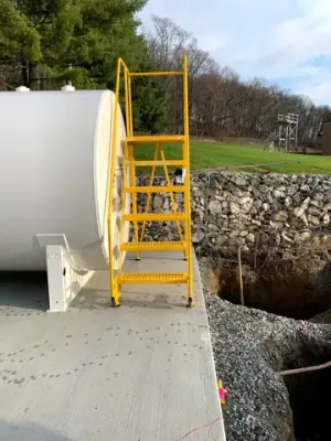Aboveground tank with a yellow access stair and platform.