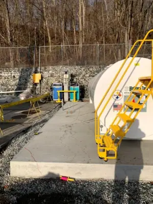 Concrete foundation and access stair along the tank installation.