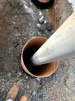 Protective steel posts set in excavated holes beside the concrete apron.
