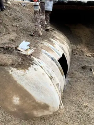 Existing underground cylindrical tank exposed in the excavation.