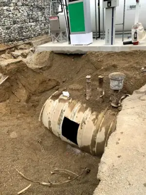 Existing underground cylindrical tank exposed in the excavation.