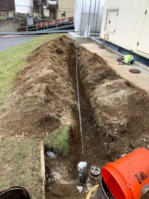 Trench and marked underground services beside the facility.