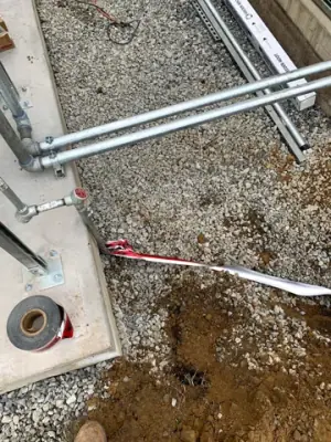 Metal conduits and fittings exposed near a round access opening.