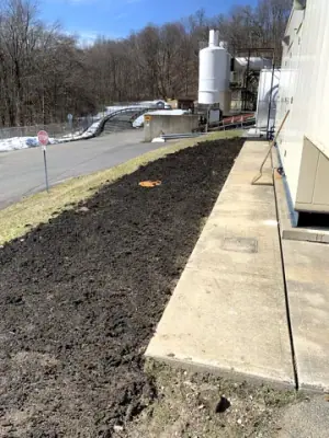 Graded ground alongside the concrete edge after utility work.
