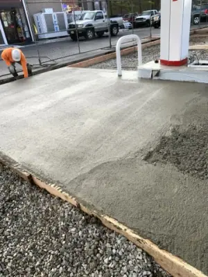 Freshly placed concrete being finished beside a canopy column.