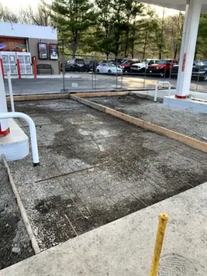 Prepared concrete bays with reinforcement and formwork around the fueling area.