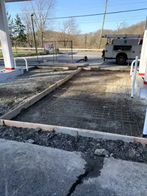 Prepared concrete bays with reinforcement and formwork around the fueling area.