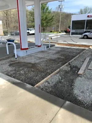 Prepared concrete bays with reinforcement and formwork around the fueling area.