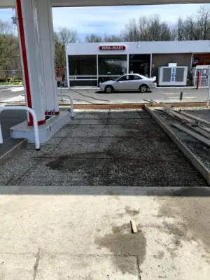 Prepared concrete bays with reinforcement and formwork around the fueling area.
