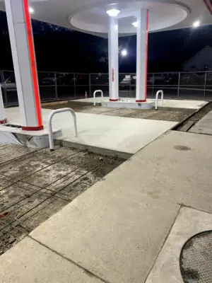 Concrete bay and reinforcing mesh under the illuminated canopy at night.