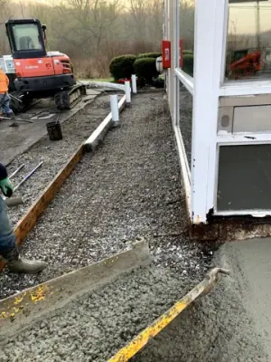 A rake levels aggregate in the prepared walkway base.