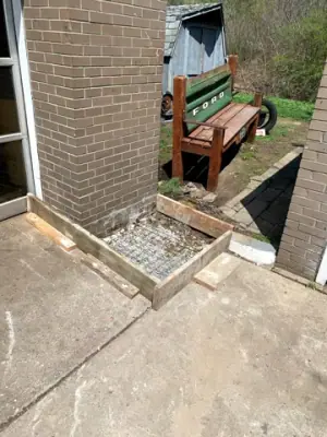 Timber forms surround an exterior landing at a service doorway.