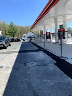 Dark asphalt strip alongside the concrete fueling apron.