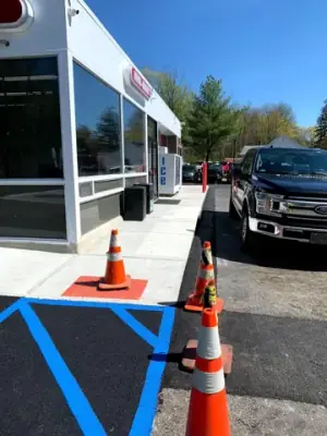 Striped accessible-parking access aisle at the building corner.