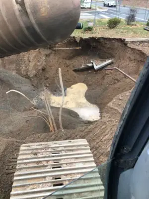 Tank lifting operation above the open excavation.