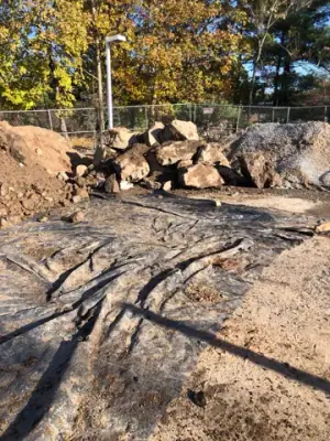 Cleared excavation area with exposed lines and stacked material.