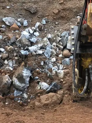 Broken rock accumulated in the excavated tank area.