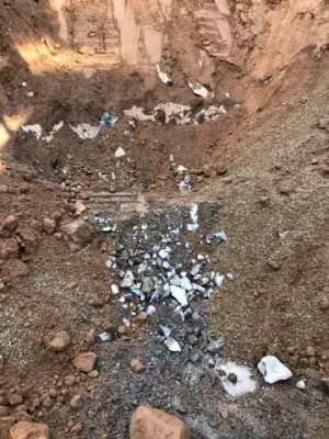 Broken rock accumulated in the excavated tank area.