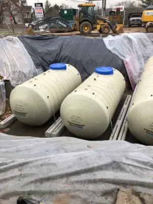 Multiple new underground tanks positioned side by side in the excavation.