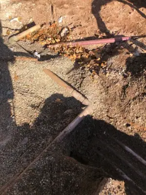 Underground pipe connections at the intersection of excavated trenches.
